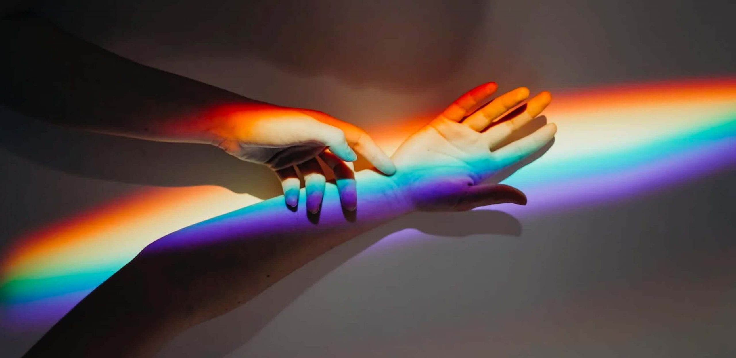 A rainbow light shining over someone's arm.